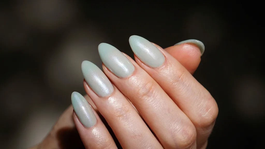 Light green cat eye manicure with shimmering magnetic effect.