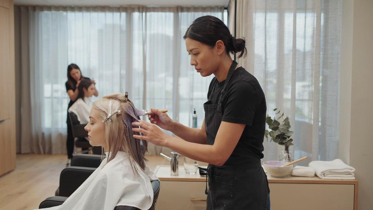 Applying toner after bleaching to achieve the final hair color.