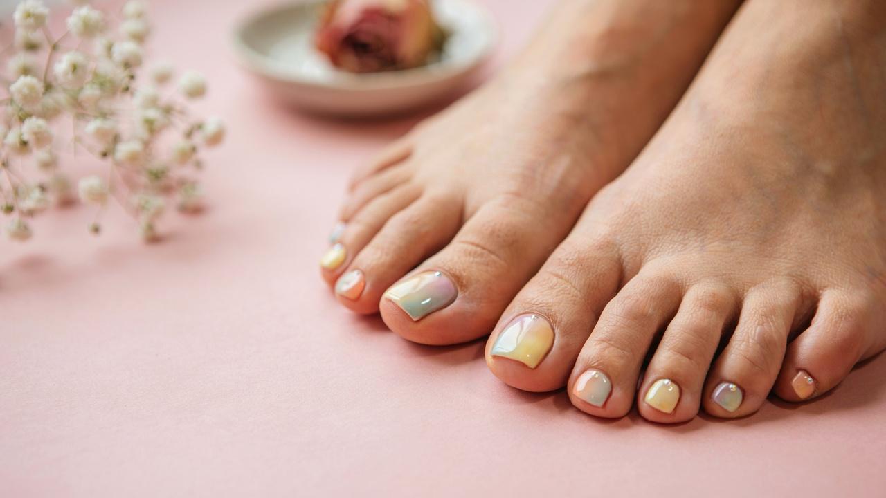 Aura toe nails with a soft glowing blended color effect.