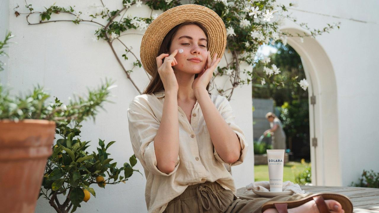 Applying sunscreen to protect acne-prone skin from harmful UV rays.