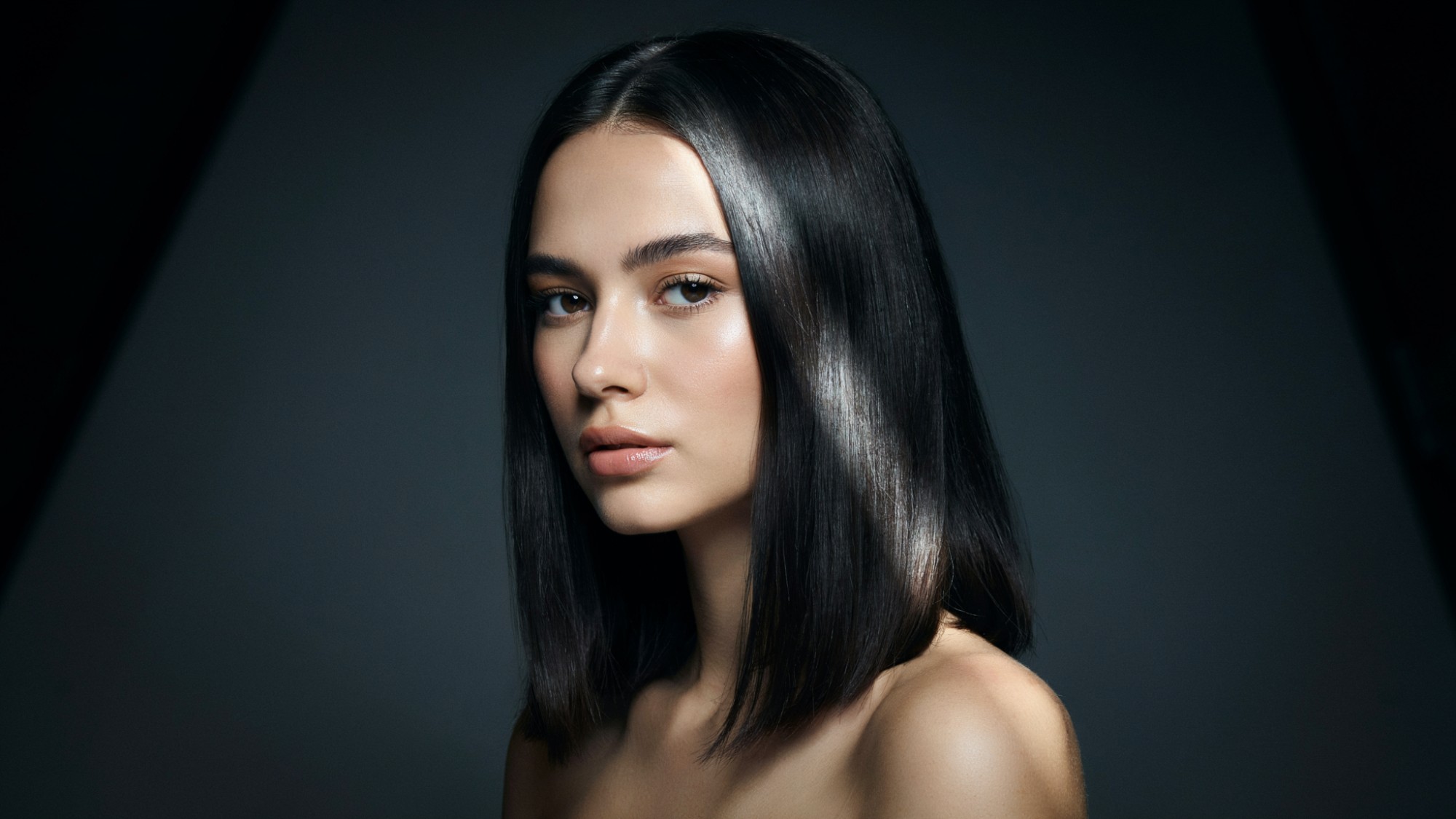 Jet black hair with intense shine and deep pigment.