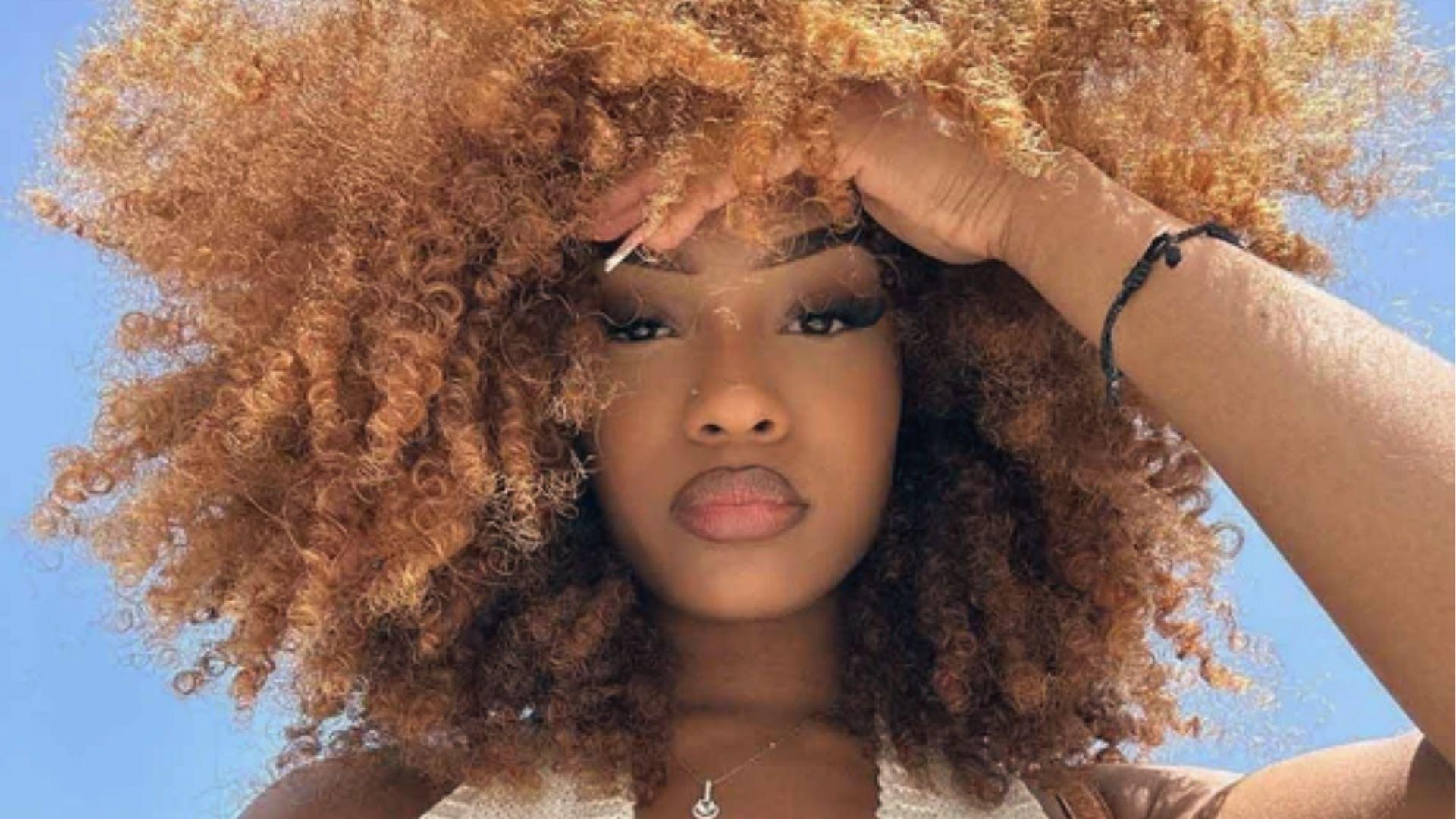 Woman with Short Afro with Highlights capturing herself on a low angle,