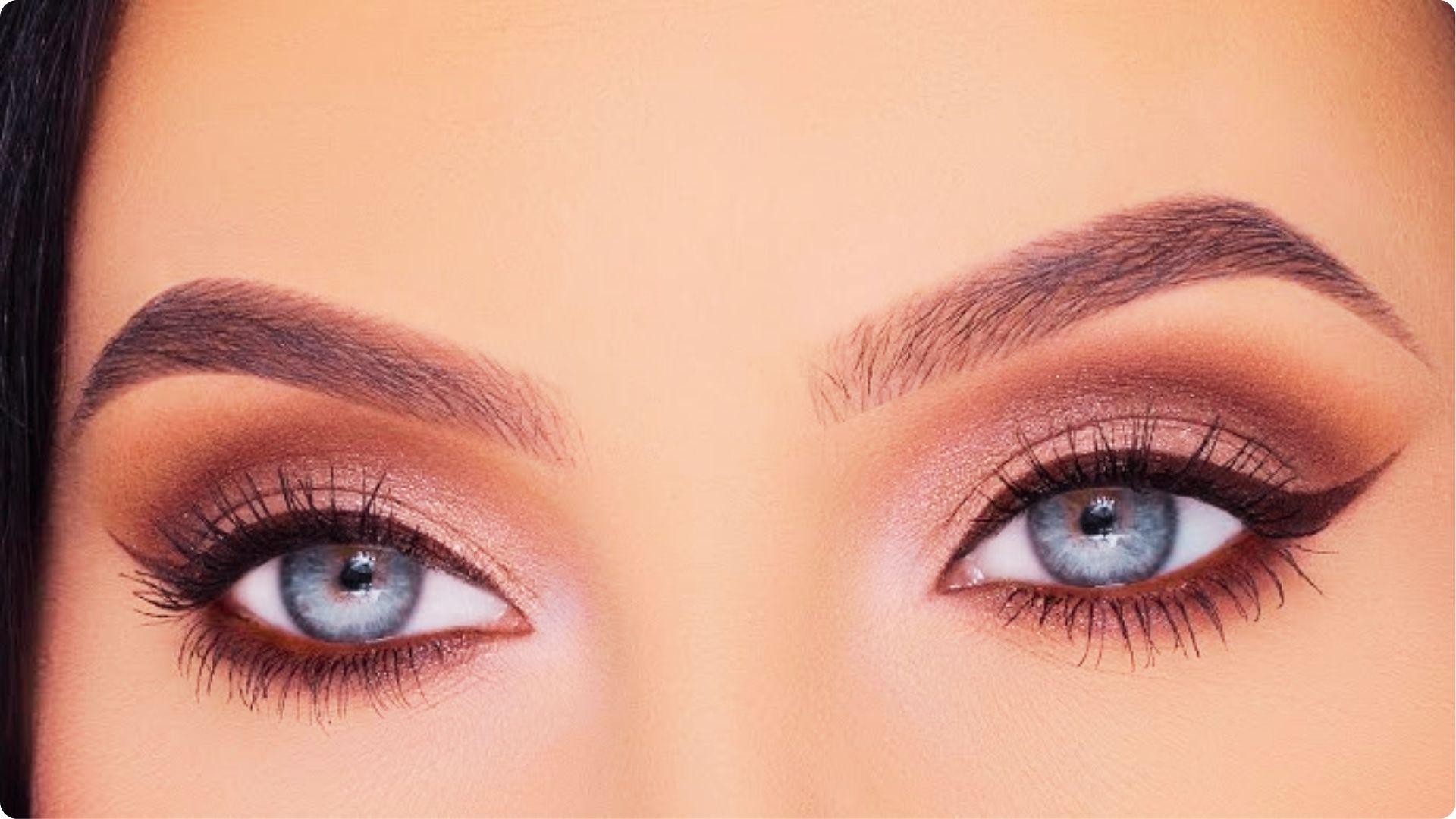 Close-up of blue eyes with soft natural wedding eye makeup in warm brown tones, smudged liner, and voluminous lashes.