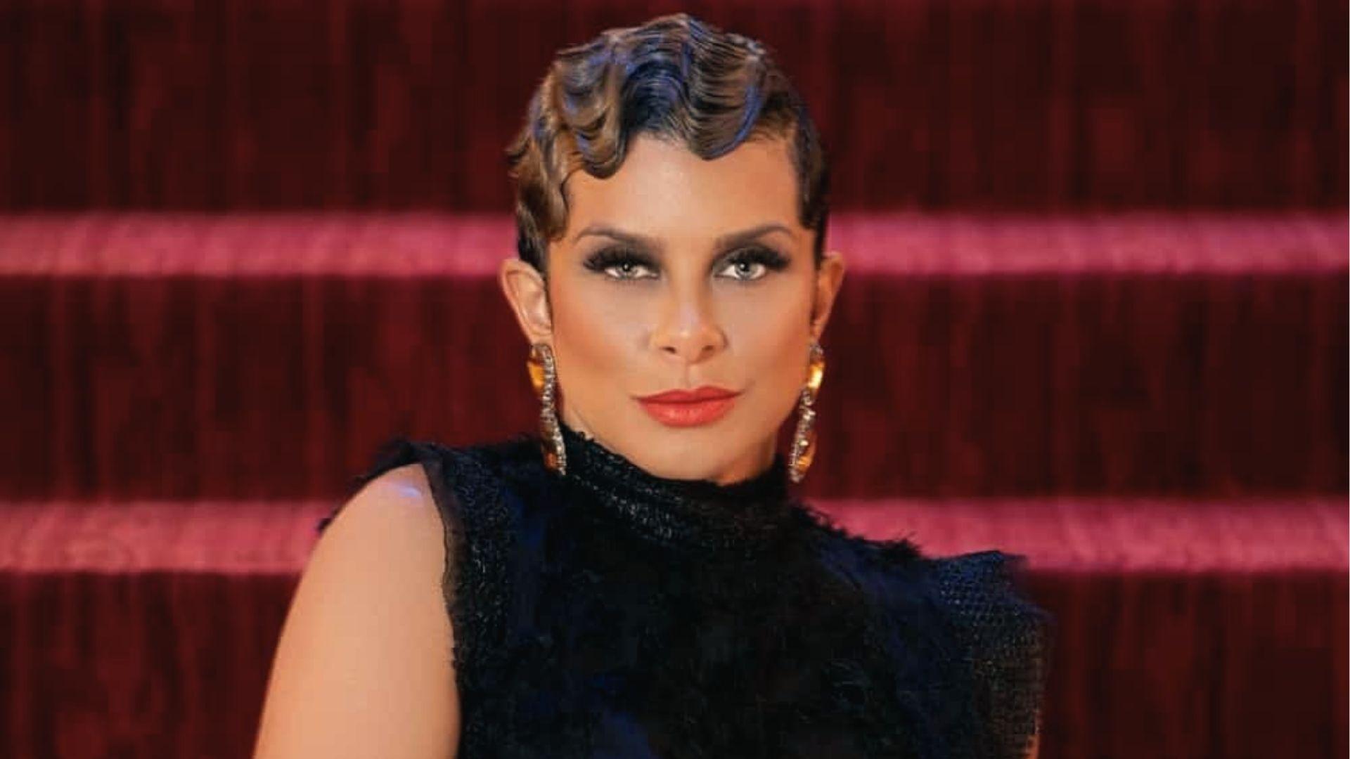 Woman on red carpet with retro finger wave pixie, black dress, statement earrings