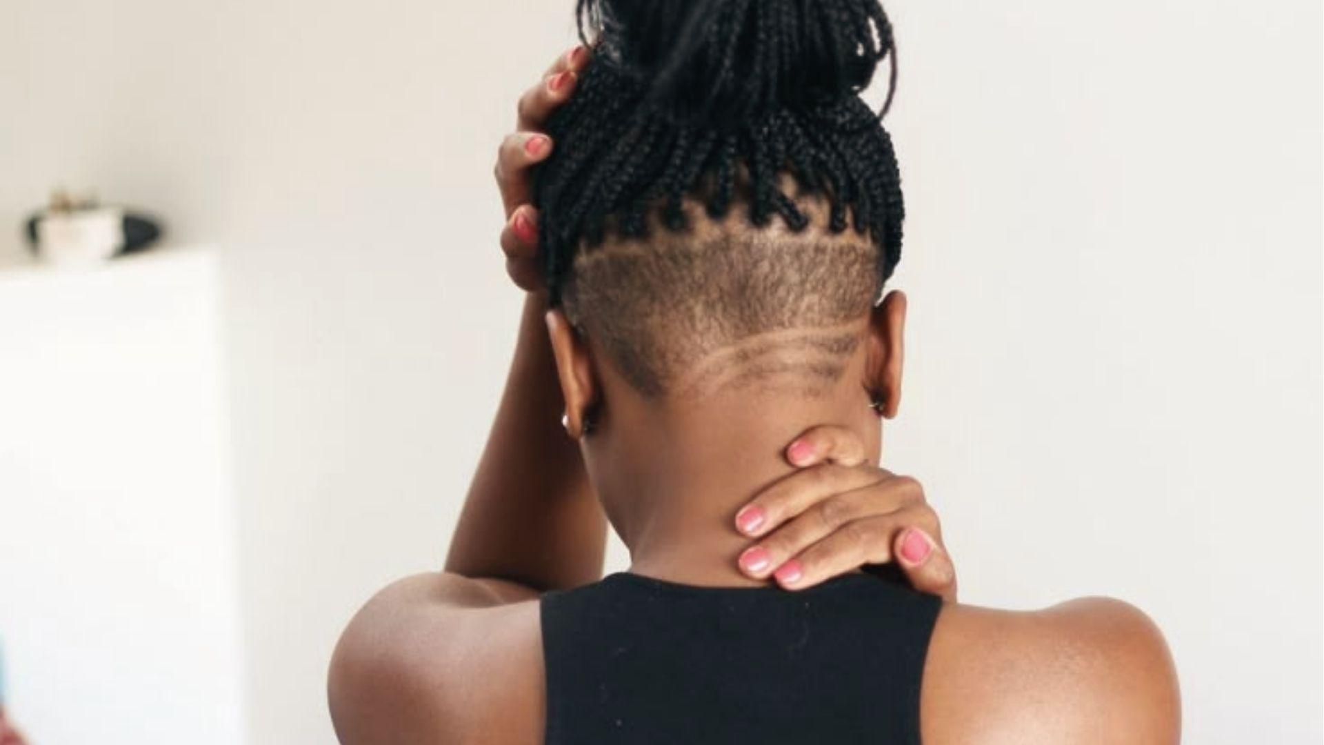 Back view of braided high bun with shaved undercut and line details, pink nails