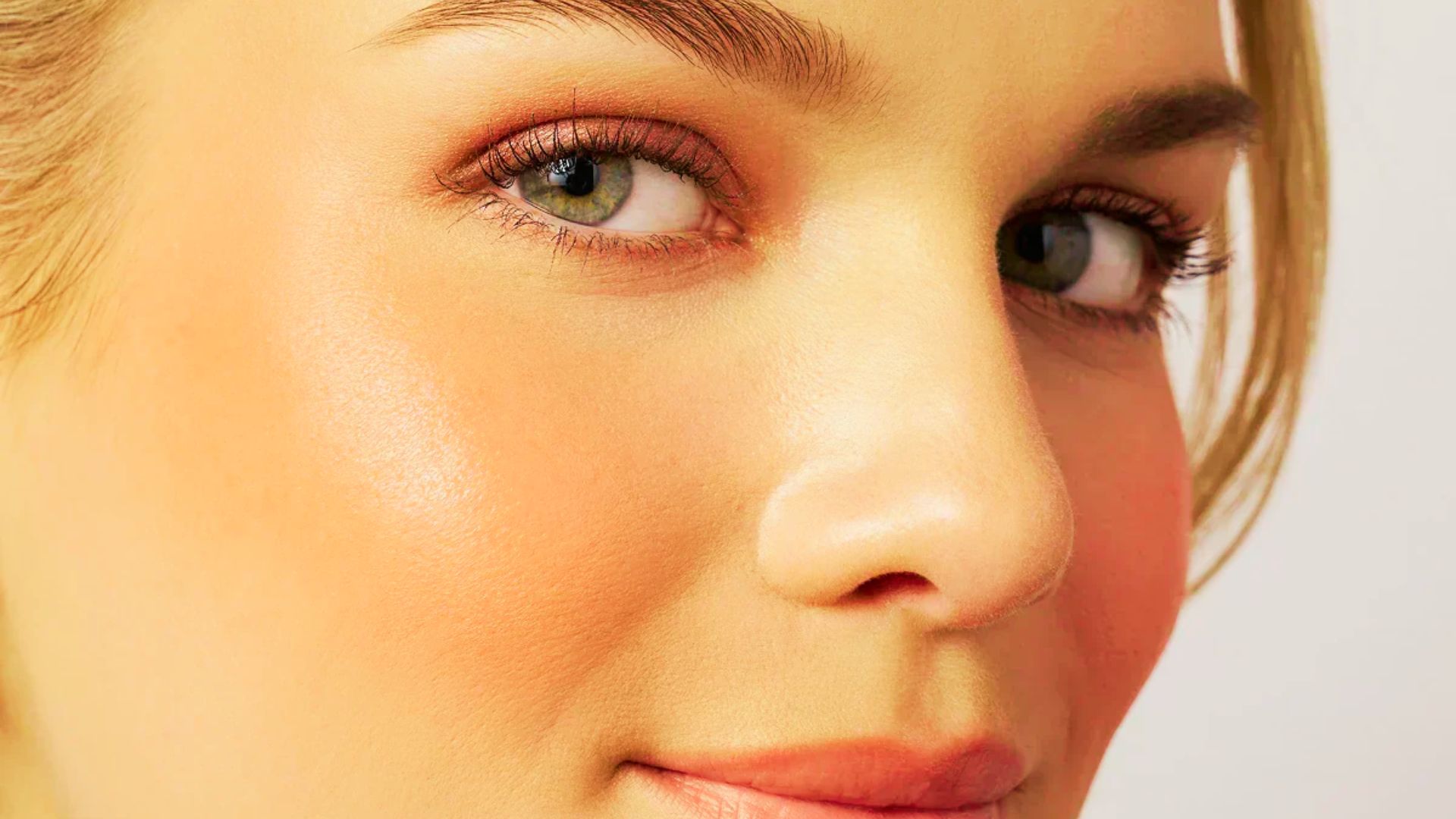 Side profile of a bride with soft rosy blush and muted pink eyeshadow.