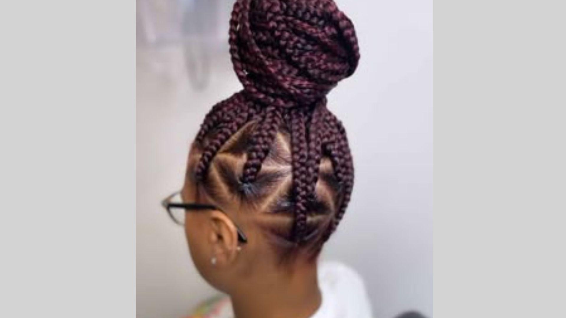 Black woman wearing jumbo braided bun hairstyle with bold voluminous braids and gold accessories
