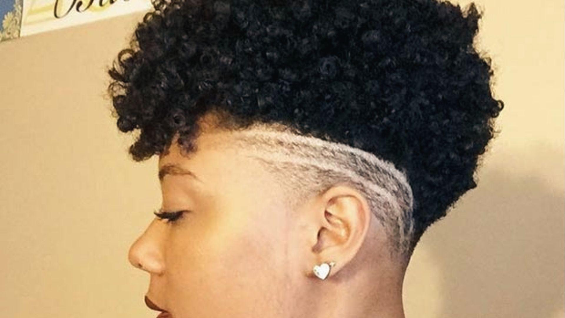 Side view of curly with shaved sides and white line design, heart earring