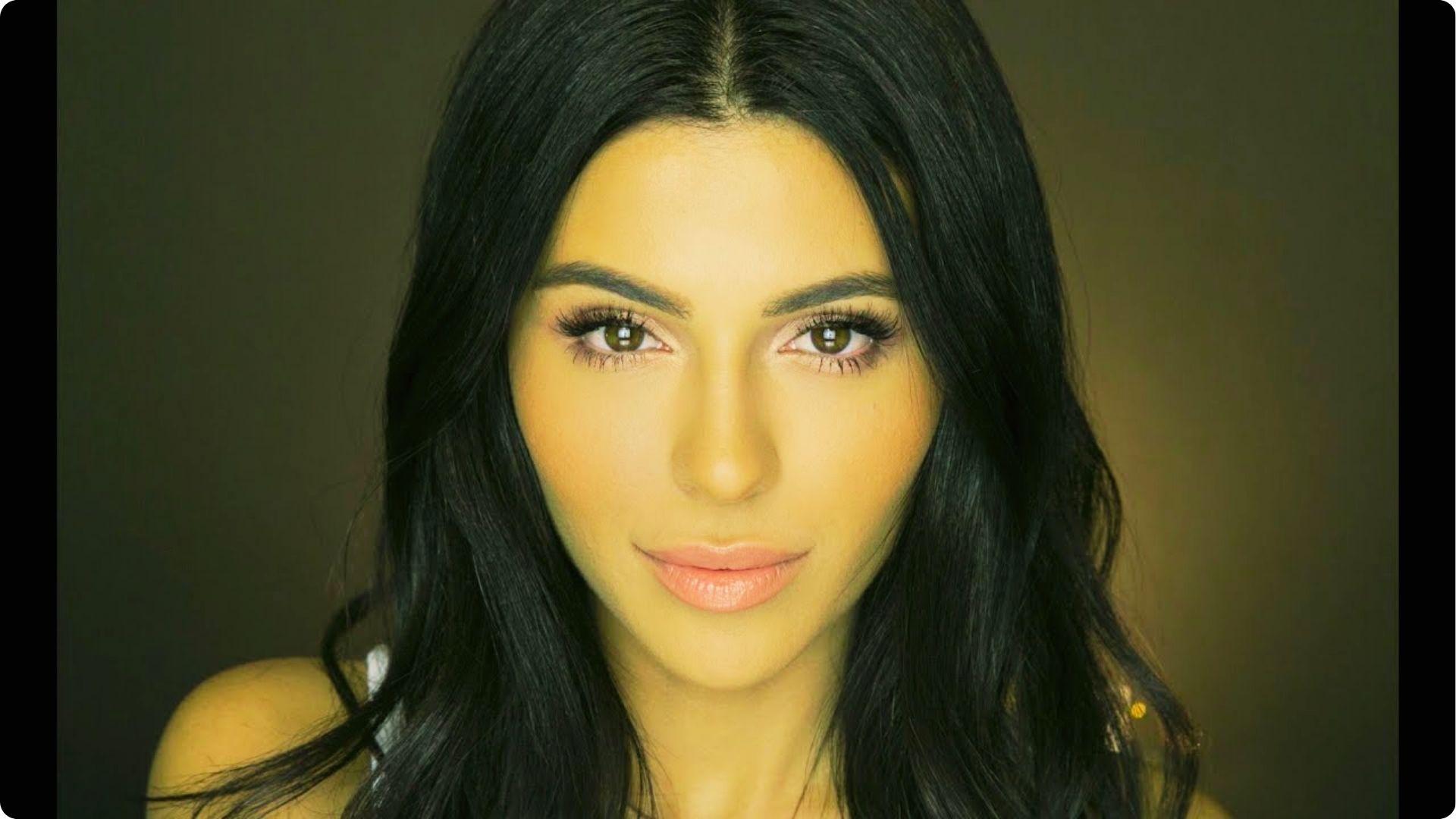 Woman with long dark hair wearing soft glam wedding makeup featuring defined brows, fluttery lashes, and a natural pink lip.
