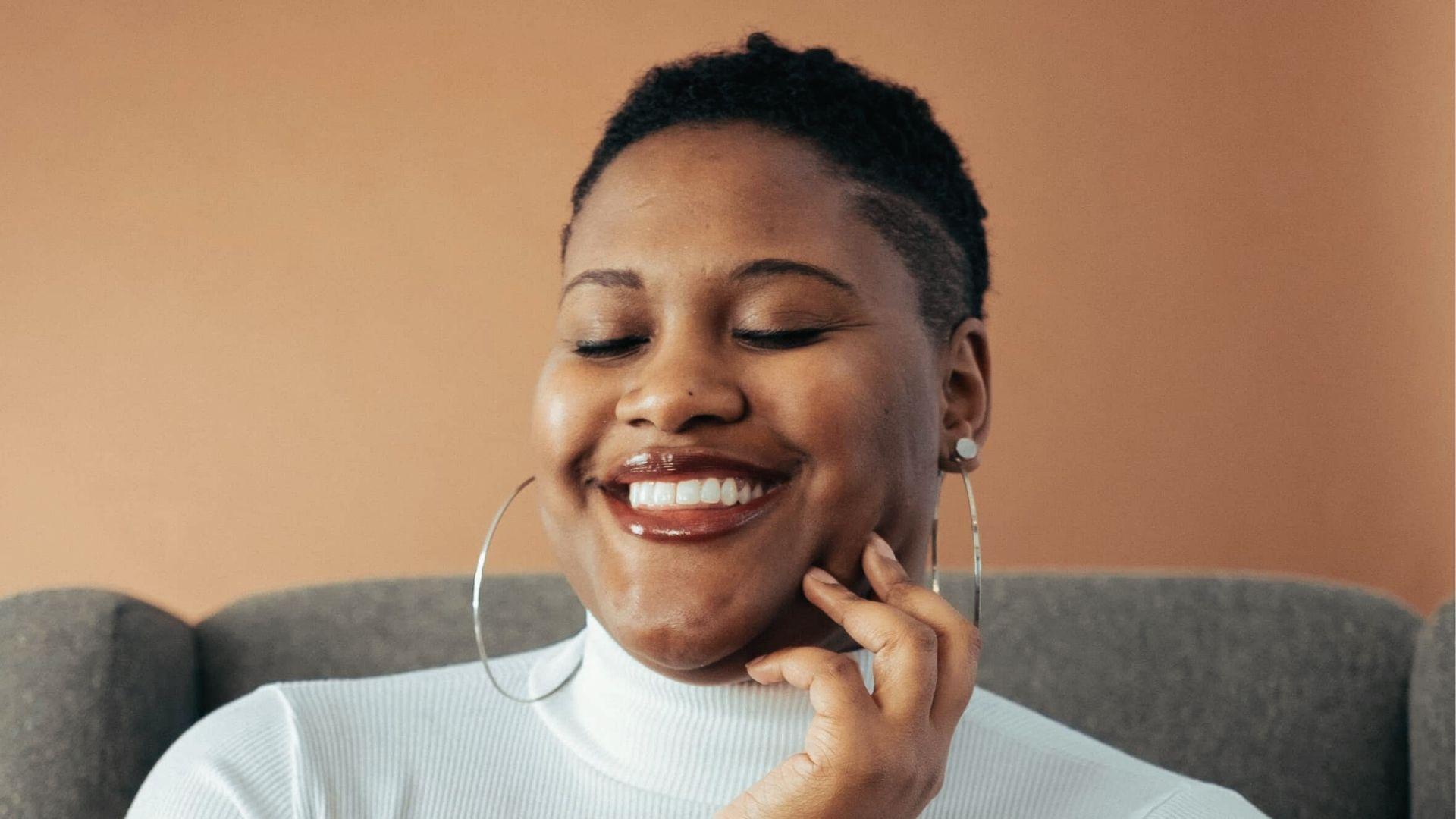 Smiling woman in white turtleneck,hoop earrings