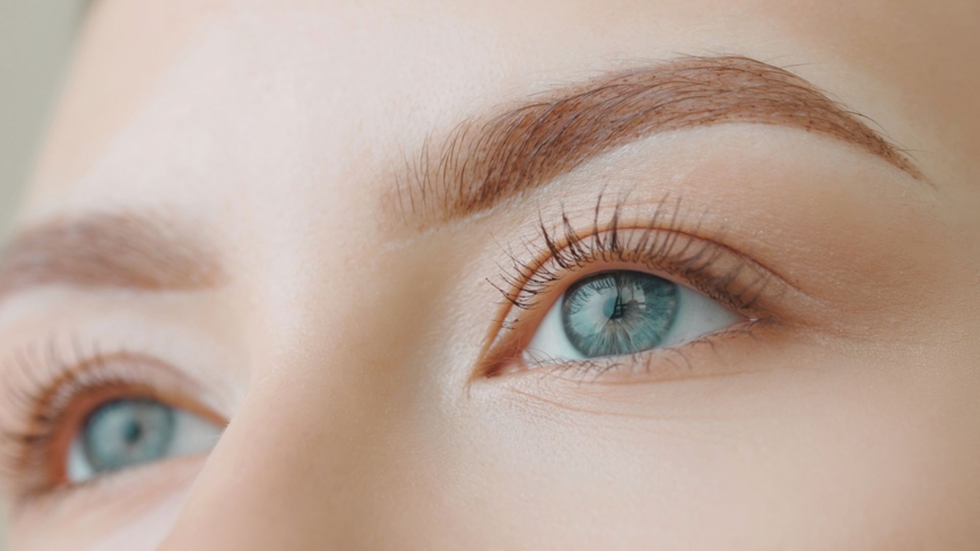Close-up of a woman's blue eyes, highlighting their vibrant color and expressive features.